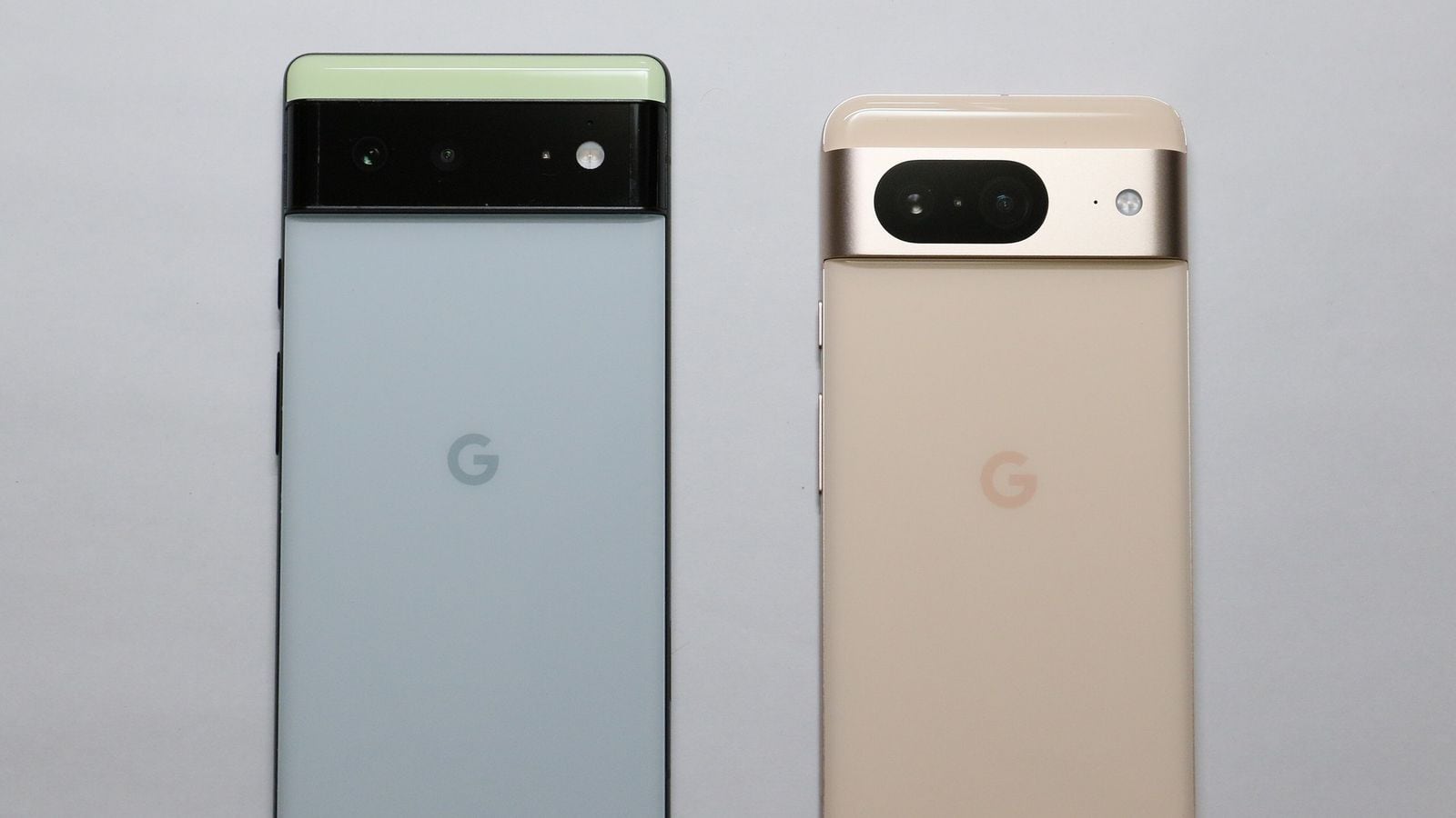 Dva telefóny Google Pixel vedľa seba zozadu, zelený Pixel 6 Pro a zlatý Pixel 8