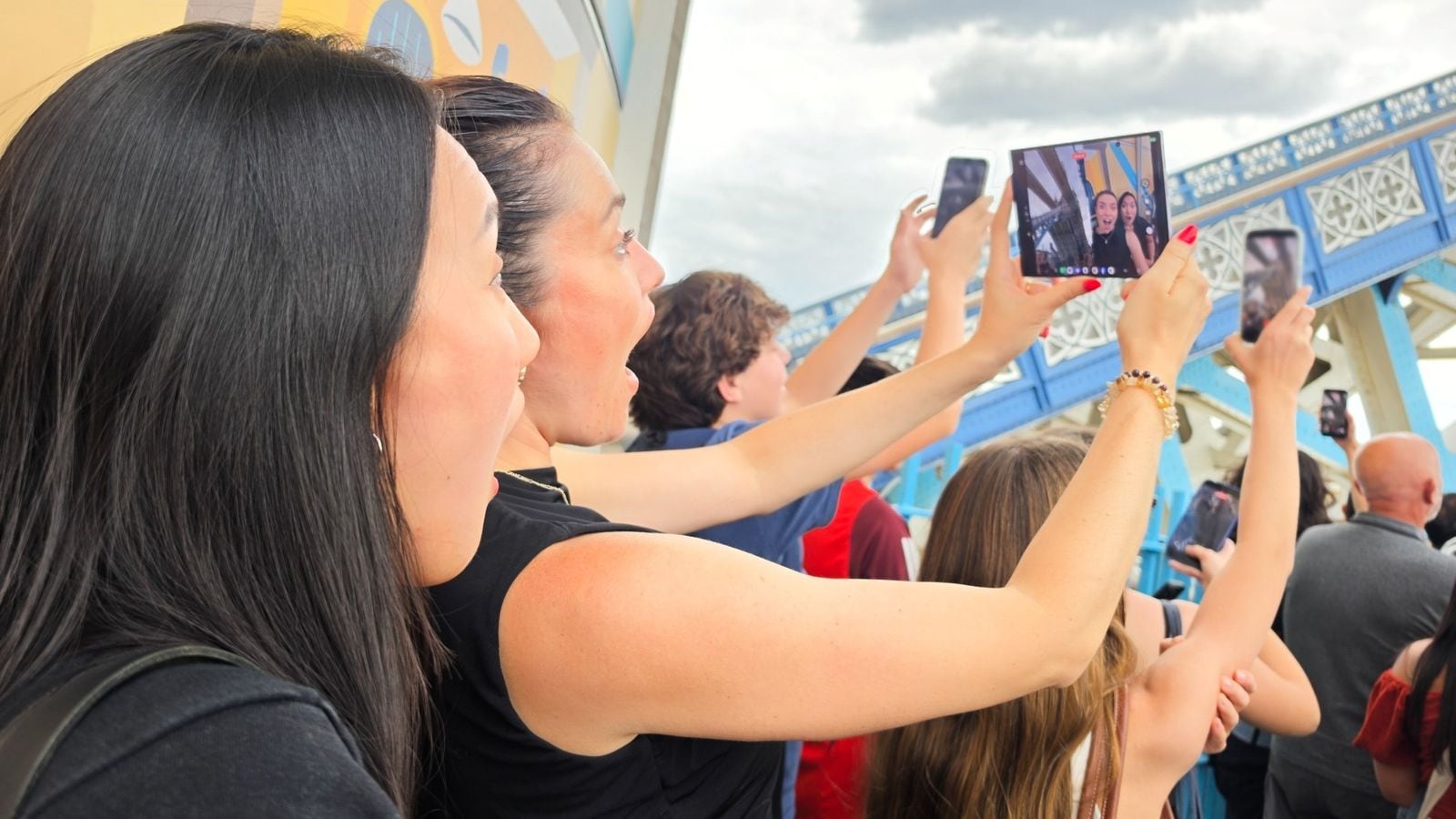 Žena drží rozložený Samsung Galaxy Z Fold a fotografuje v dave na Tower Bridge