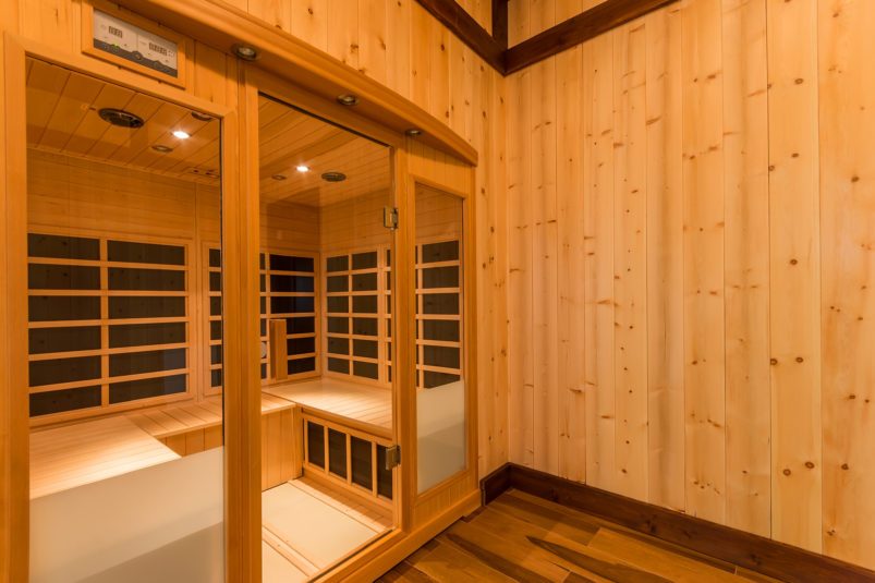 Infrasauna pre dve osoby so sklenenými dverami a tmavými karbónovými panelmi na stenách